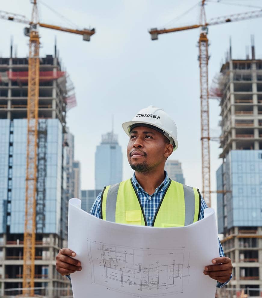 Tobechukwu Nwachukwu, CEO of Cruxatec, on site at a construction project wearing a #CRUXATECH hard hat