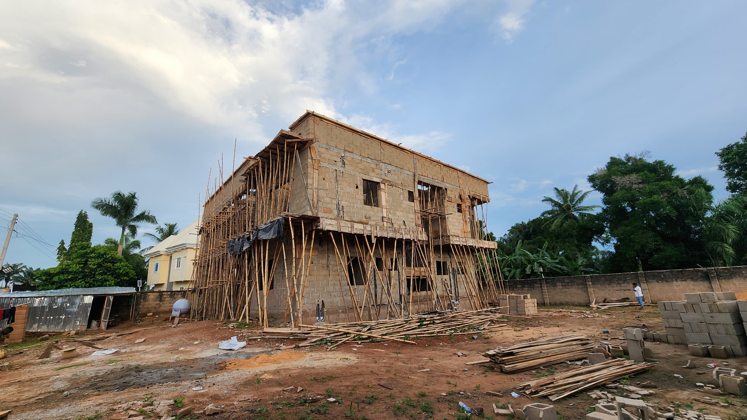 Building under construction with bamboo scaffolding at dusk